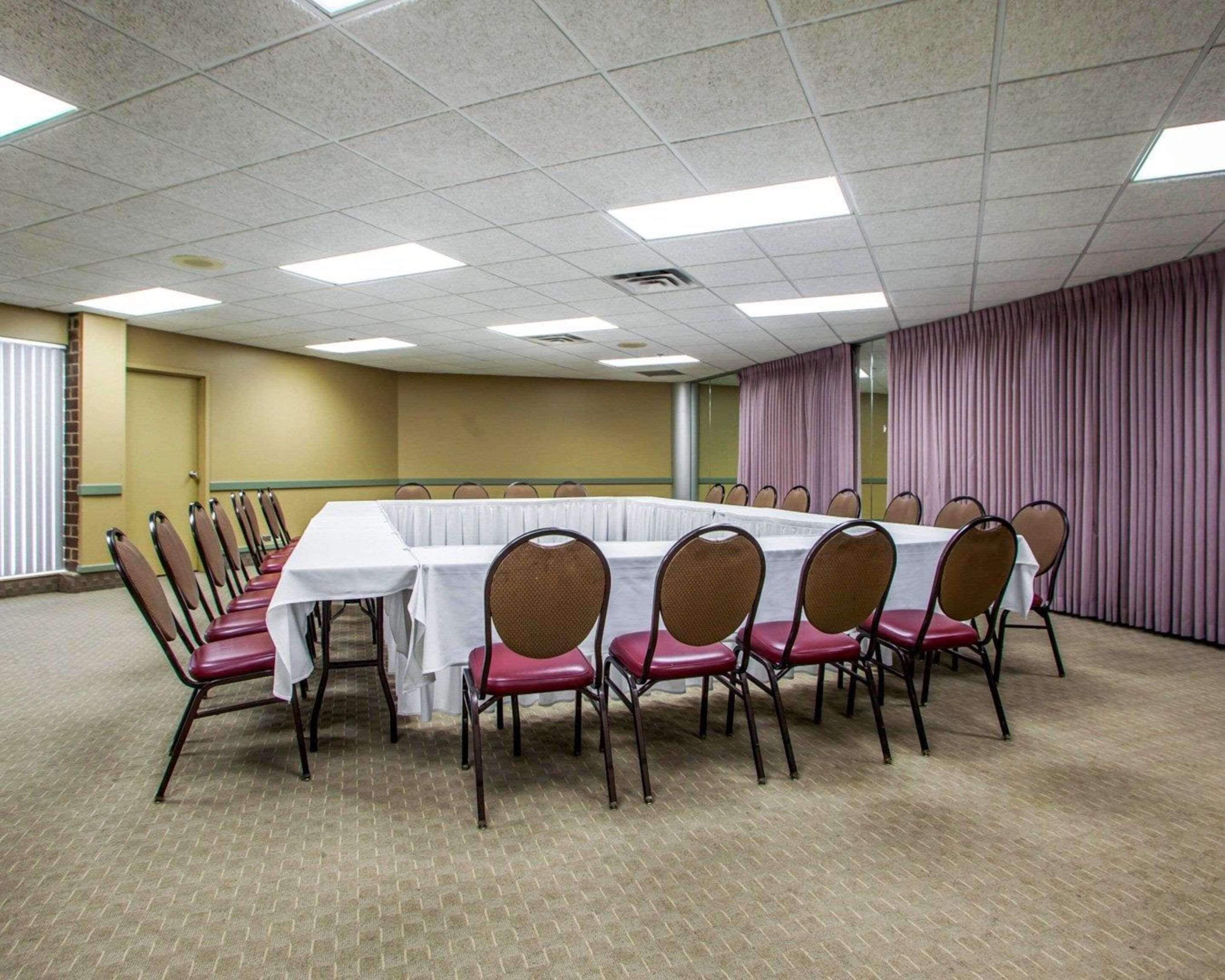 A conference room with a long table, chairs, and a carpeted floor.