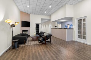 A spacious living area with a fireplace, a flat-screen TV, a sofa, and a coffee table.