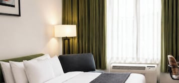 Escritorio, cortinas blackout y tabla de planchar con plancha