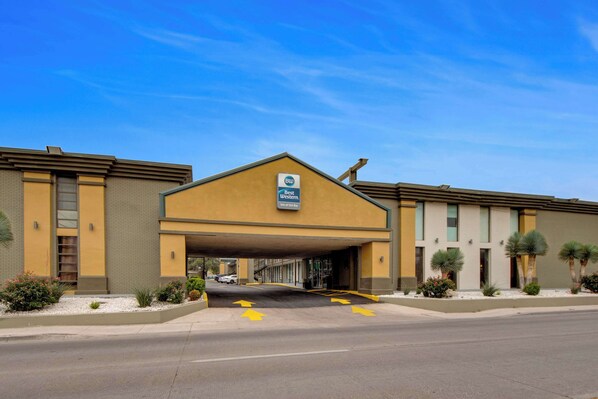 A Best Western hotel with a covered entrance, clear signage, and a parking lot with directional arrows.