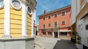 Una calle con edificios, incluyendo un edificio rojo con el cartel 'Hotel de Santa Maria'.