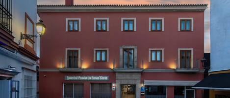 Un edificio rojo con varias ventanas, un letrero que dice 'Mercado de Santa Maria' y una puerta con un cartel encima.