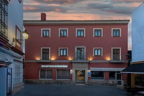 Un edificio rojo con varias ventanas, un letrero que dice 'Mercado de Santa Maria' y una puerta con un cartel encima.