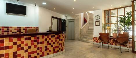 A reception area with a tiled counter, a clock, and a staircase.