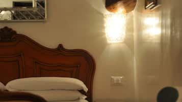 Une chambre d’hôtel avec un lit en bois, un miroir, une table de chevet et une chaise.