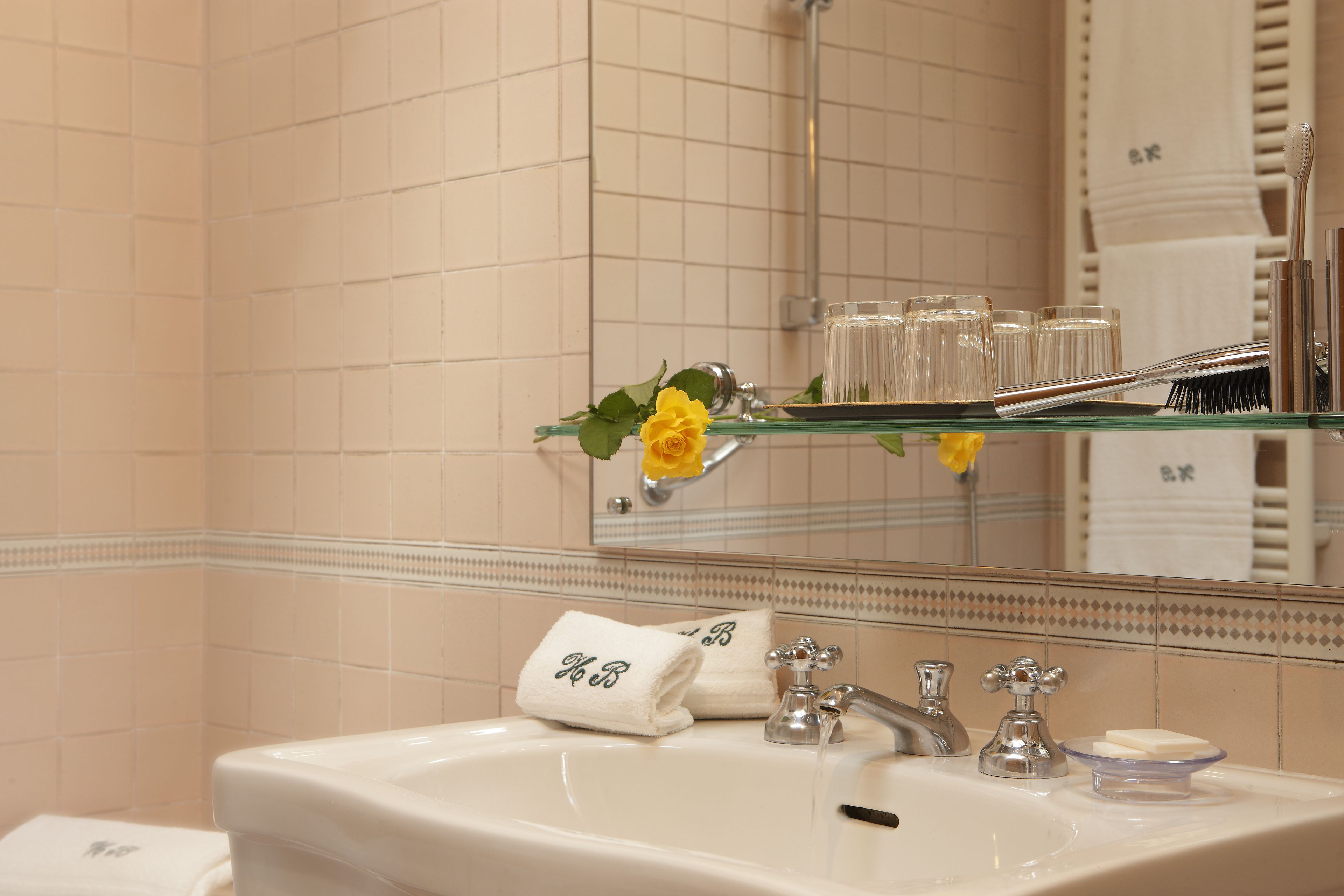 Un baño con lavamanos, espejo y artículos de aseo.