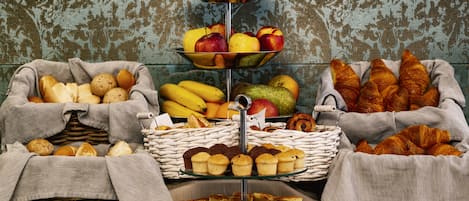 Een buffet met diverse gebakjes, fruit en patisserie.