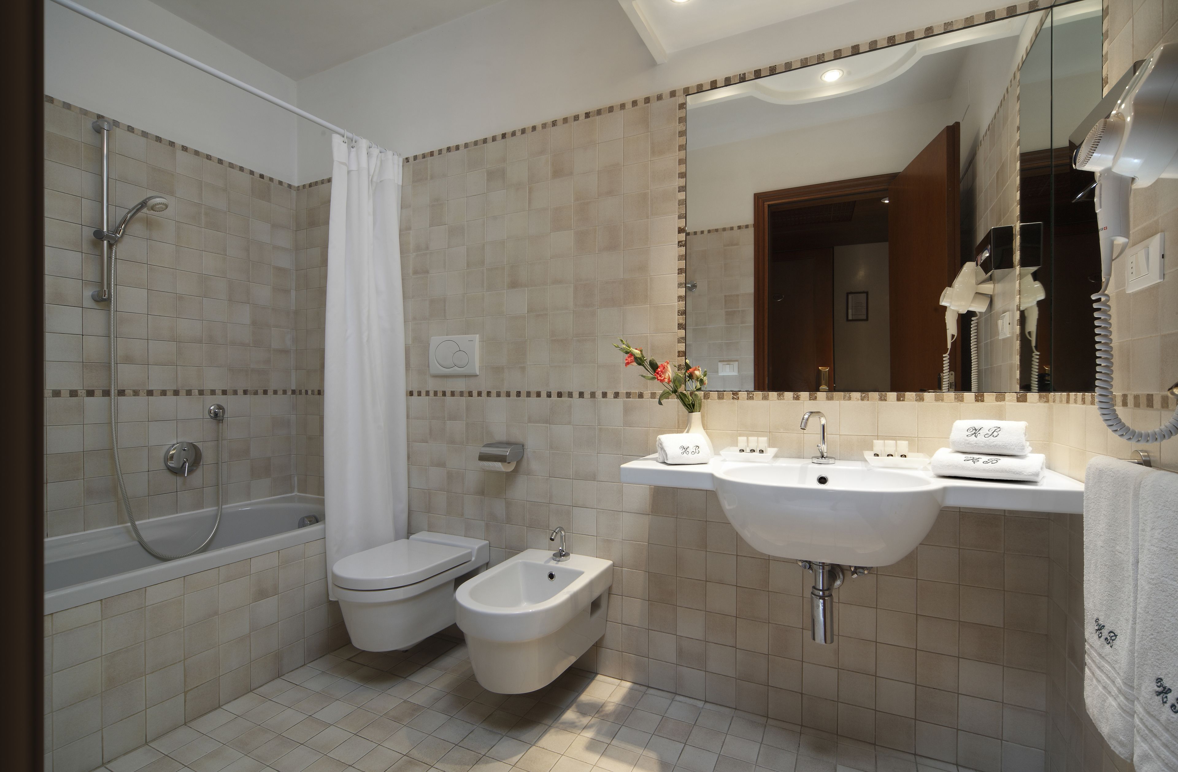 A bathroom with a bathtub, toilet, bidet, and sink.