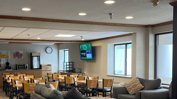 A spacious hotel lobby with multiple seating areas, a digital clock, and a television screen. - Quality Inn Wilkes-Barre near Arena (Wilkes-Barre)