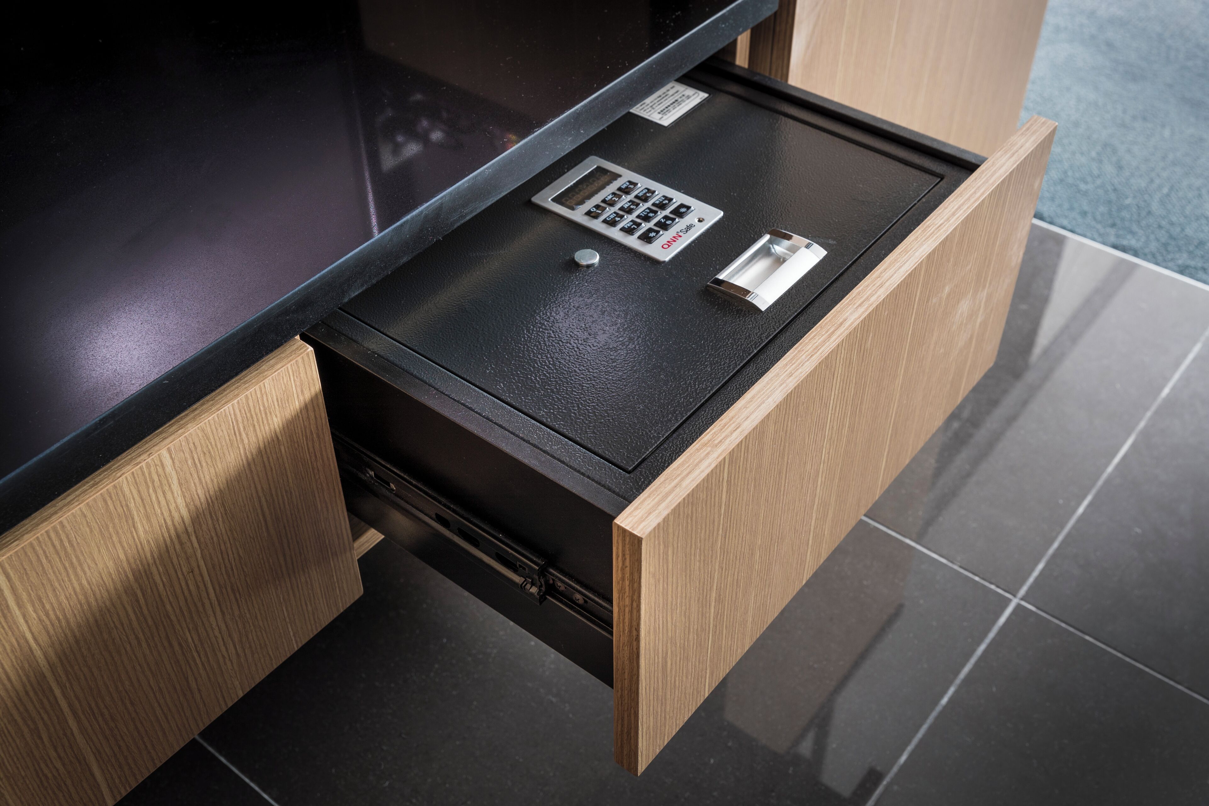 A modern office desk with a built-in keyboard and a small slot, likely for a mouse.