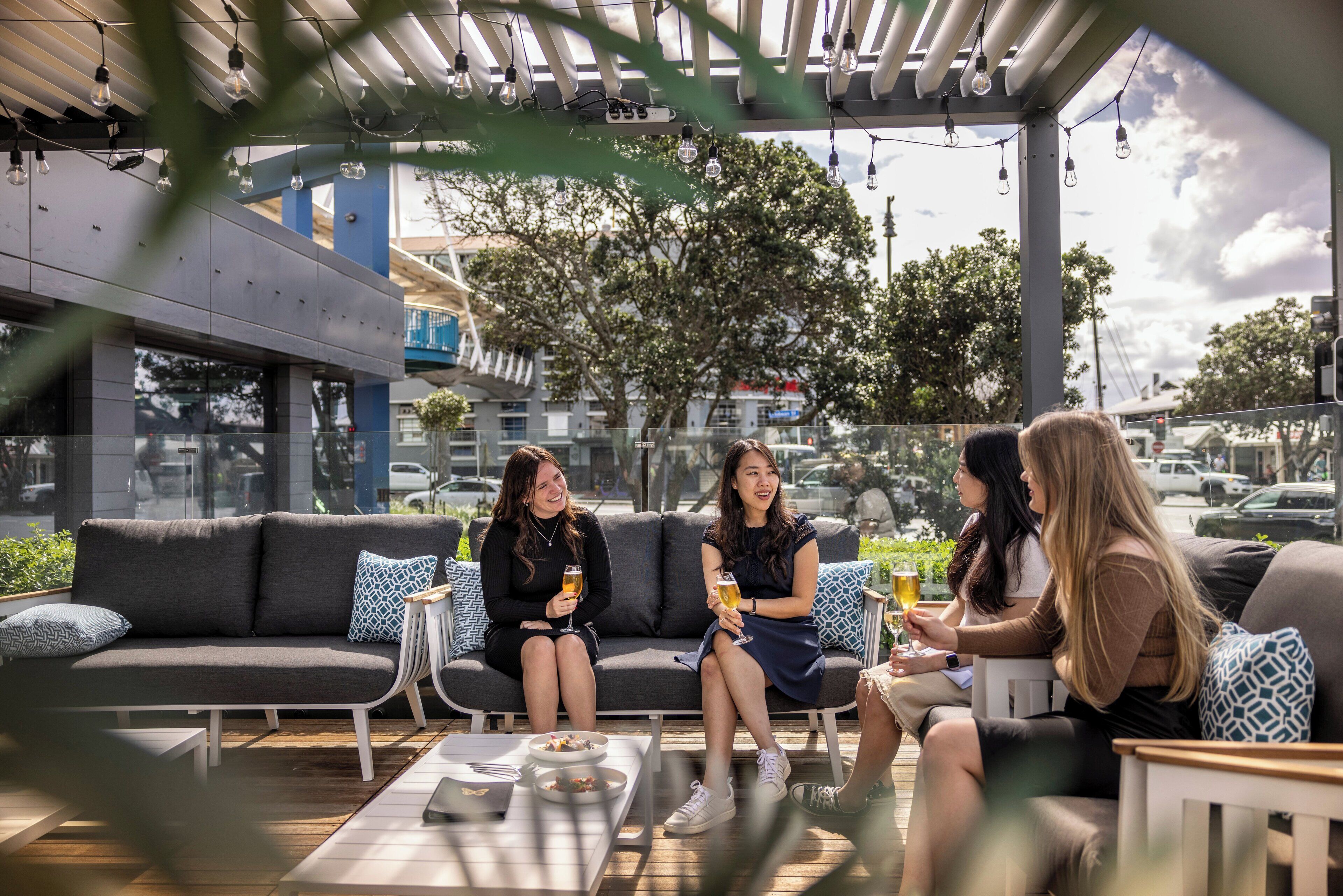 An outdoor seating area with a sofa, small tables, and chairs.