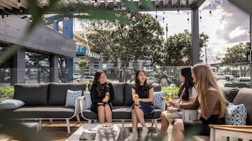 An outdoor seating area with a sofa, small tables, and chairs.