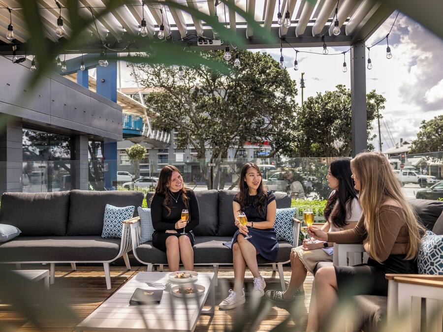 An outdoor seating area with a sofa, small tables, and chairs.