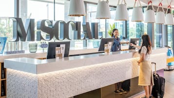Un comptoir d’accueil orné d’une grande enseigne « MS SOCIAL », un design moderne aux motifs géométriques et une vue sur l’extérieur grâce à de grandes fenêtres.