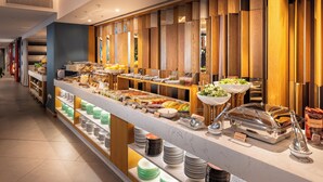 A buffet area with various food items and serving utensils. - M Social Hotel Auckland (Auckland)