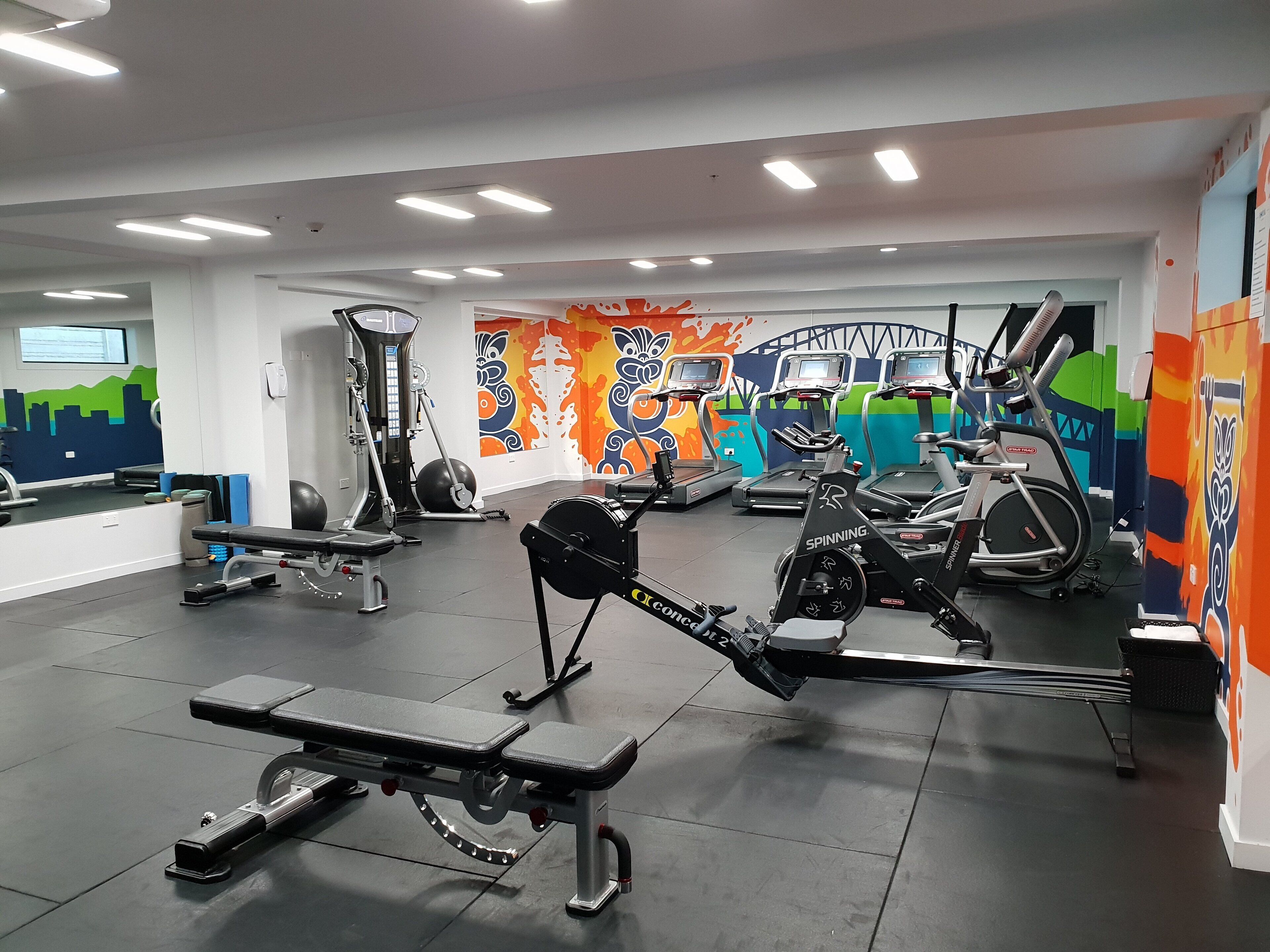 A gym with treadmills, stationary bikes, and weight machines.