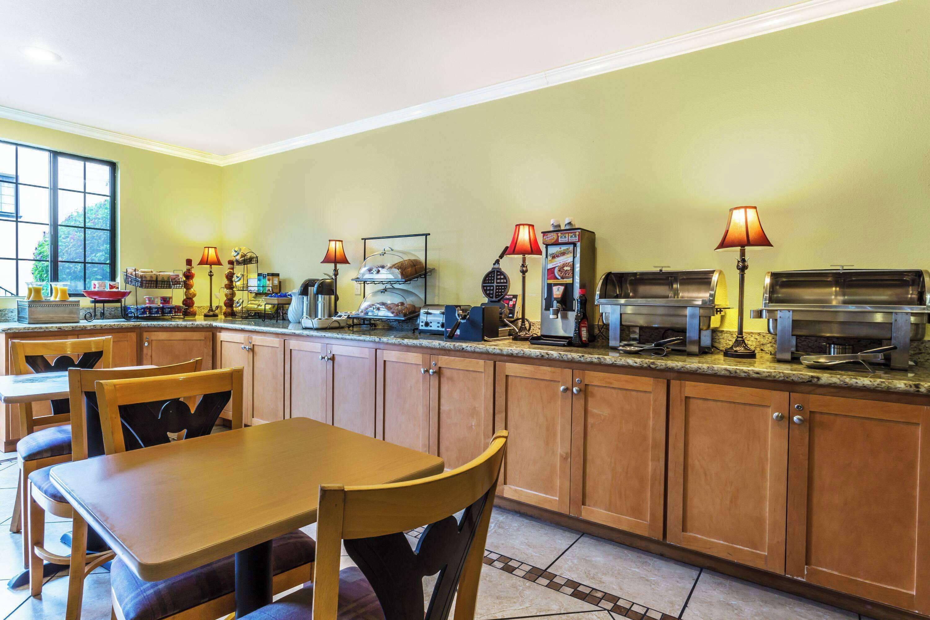 A kitchen with wooden cabinets, a granite countertop, and various appliances including a coffee maker and a toaster.