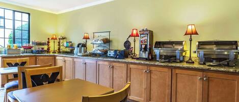 A kitchen with wooden cabinets, a granite countertop, and various appliances including a coffee maker and a toaster.