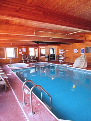 An indoor swimming pool with a wooden ceiling, a lifeguard chair, and a covered bench. - Red Roof Inn Fargo - I-94/ Medical Center (Fargo)