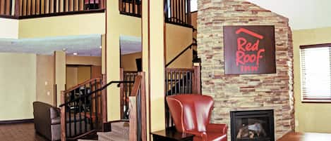 Un interior espaiós amb una escala, un butaquesa de pell i una llar de foc.