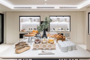 A buffet setup with various food items and containers.