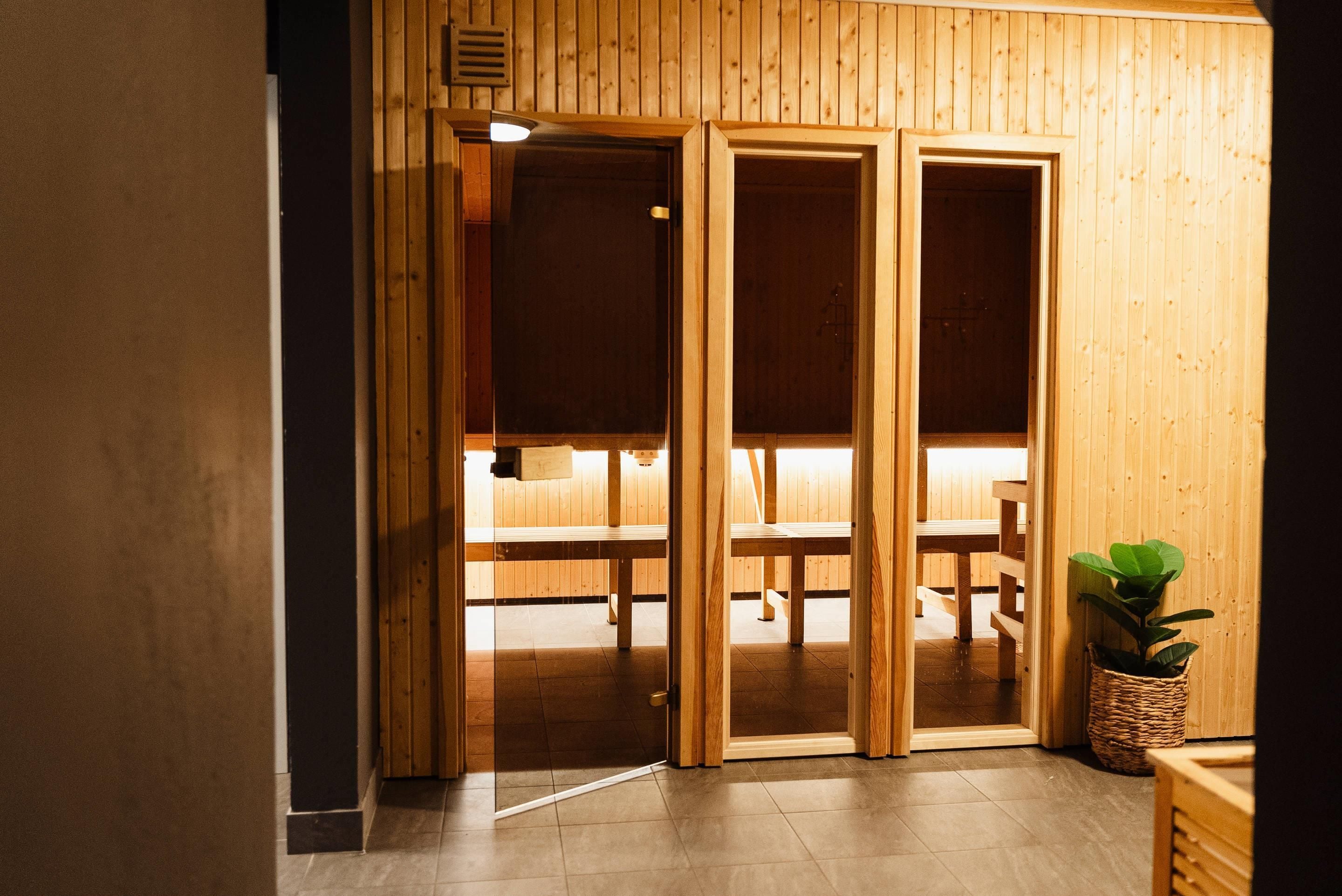 Una puerta corredera de madera que da a una habitación con un banco y una planta en maceta.