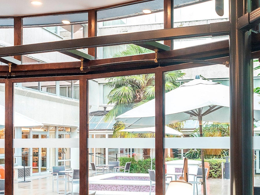 A spacious indoor area with a pool, multiple seating areas, and a view of the outdoors.