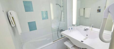 Un bagno moderno con doccia vetrata, lavandino bianco con specchio e portasciamani.