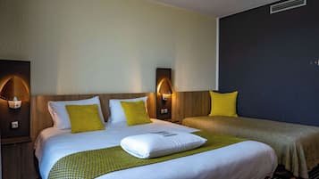 Ein Hotelzimmer mit einem großen Bett, zwei Nachttischen, einer Ablage und einer Wandlampe.