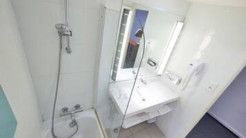 A modern bathroom with a glass shower enclosure, a white sink, and a mirror.