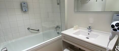 A modern bathroom with a glass-enclosed shower, a white sink with a mirror above it, and a towel rack.