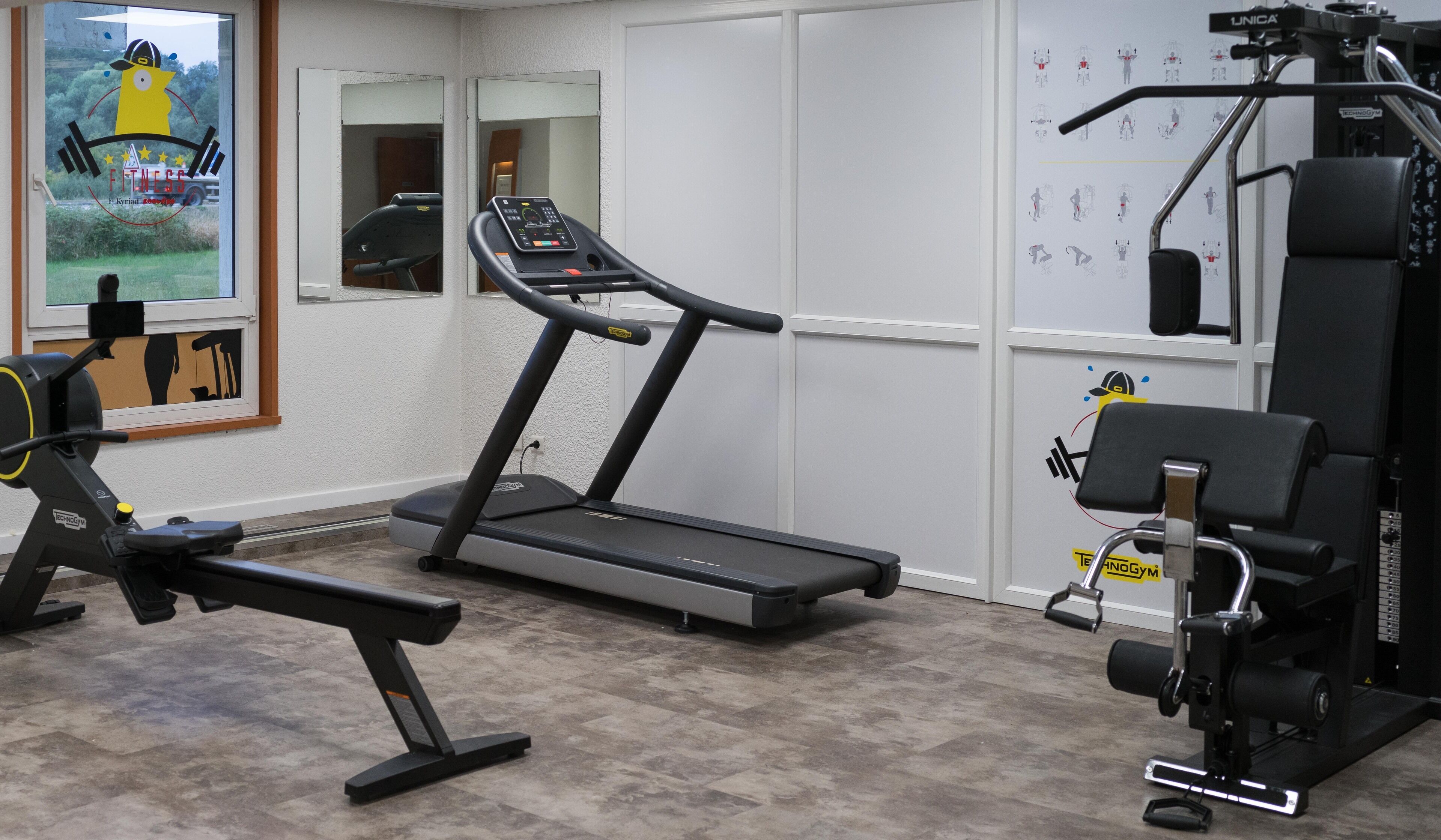 Une salle de sport équipée d’un tapis de course, d’un banc de développé couché et d’appareils de musculation.