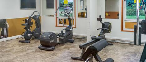 A gym with various exercise equipment, including treadmills, stationary bikes, and weight machines.