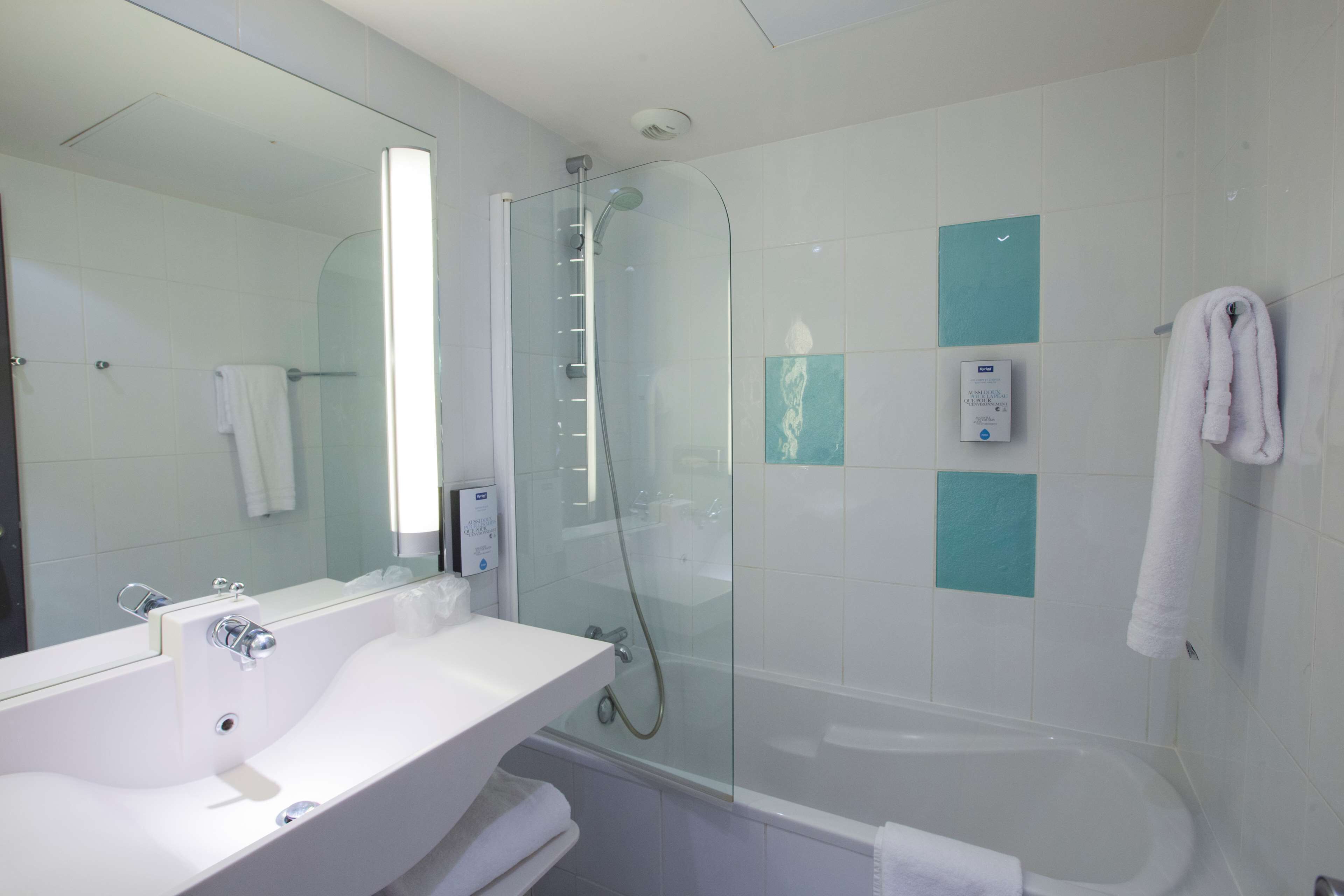 A modern bathroom with a glass-enclosed shower, a white sink, and a bathtub.