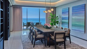 A modern dining area with a long table, chairs, and a view of the ocean. - The St. Regis Longboat Key Resort (Longboat Key)