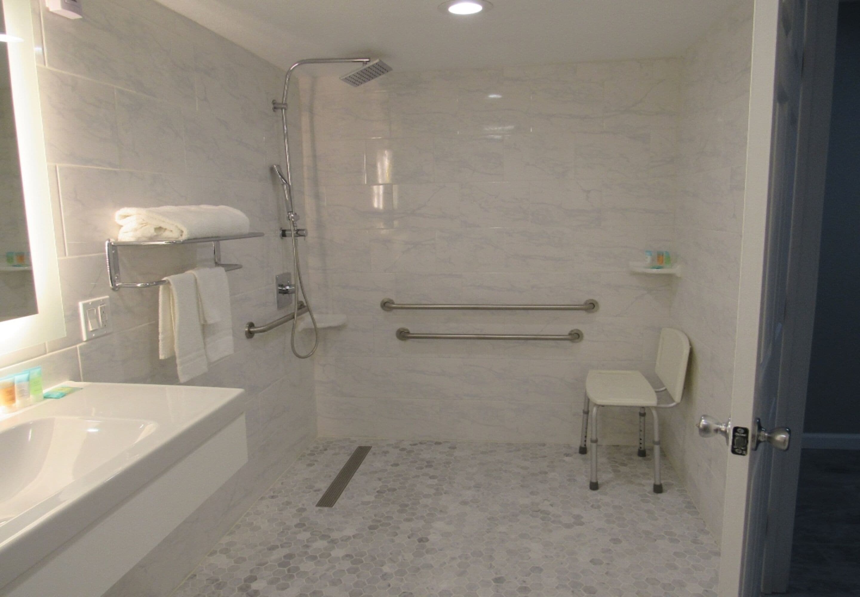 Een moderne badkamer met een bad, douche en toilet.