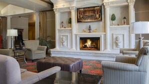 A spacious living room with a fireplace, comfortable seating, and a large framed picture above the mantel.