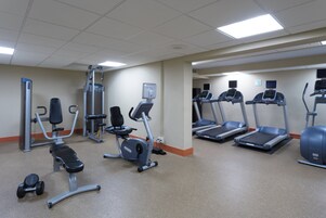 A gym with various exercise equipment including treadmills, an elliptical, and weight machines.