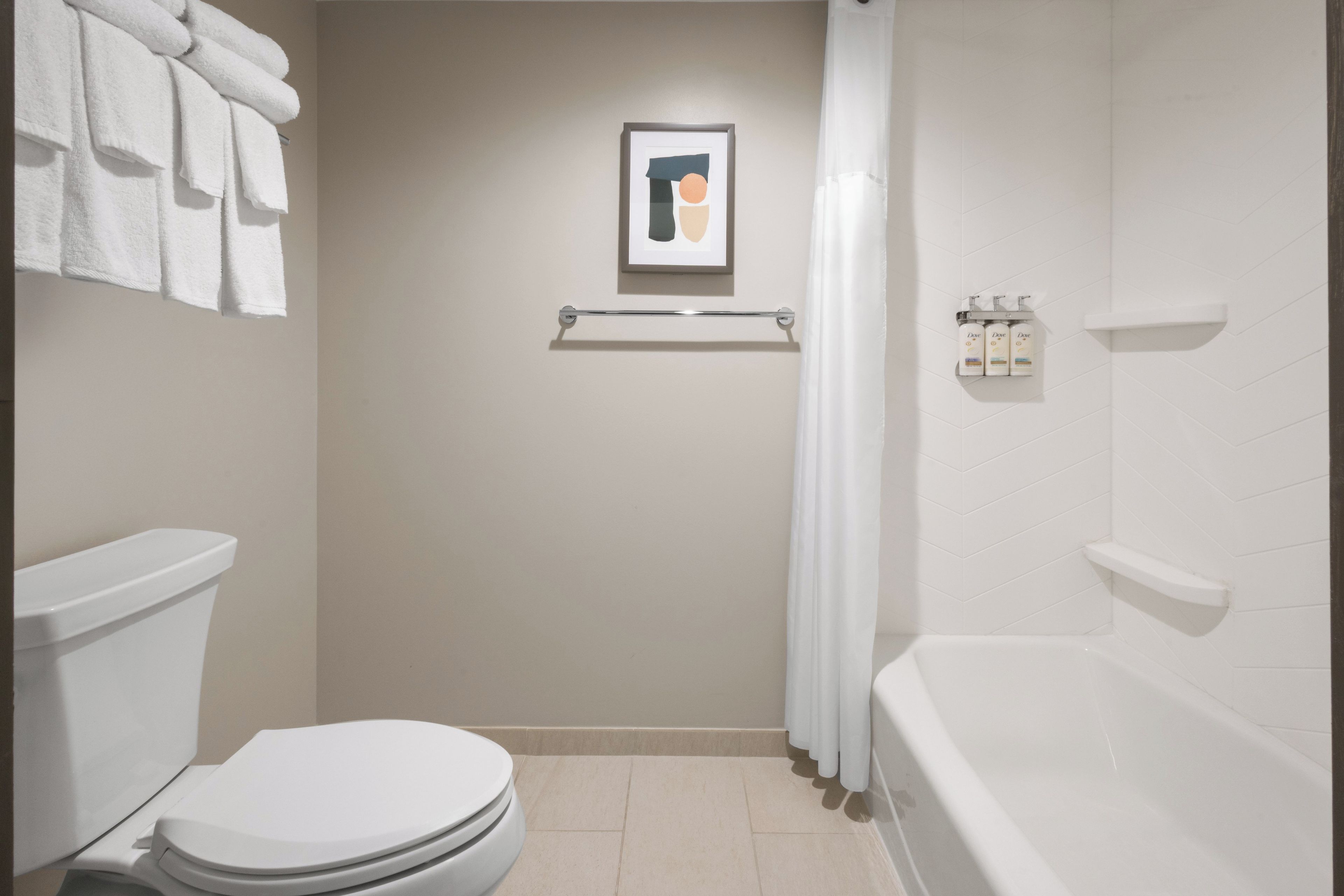 A bathroom with a toilet, a shower, and a towel rack.