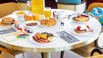 Una mesa de desayuno con diferentes platos, como panqueques, huevos y tostadas.