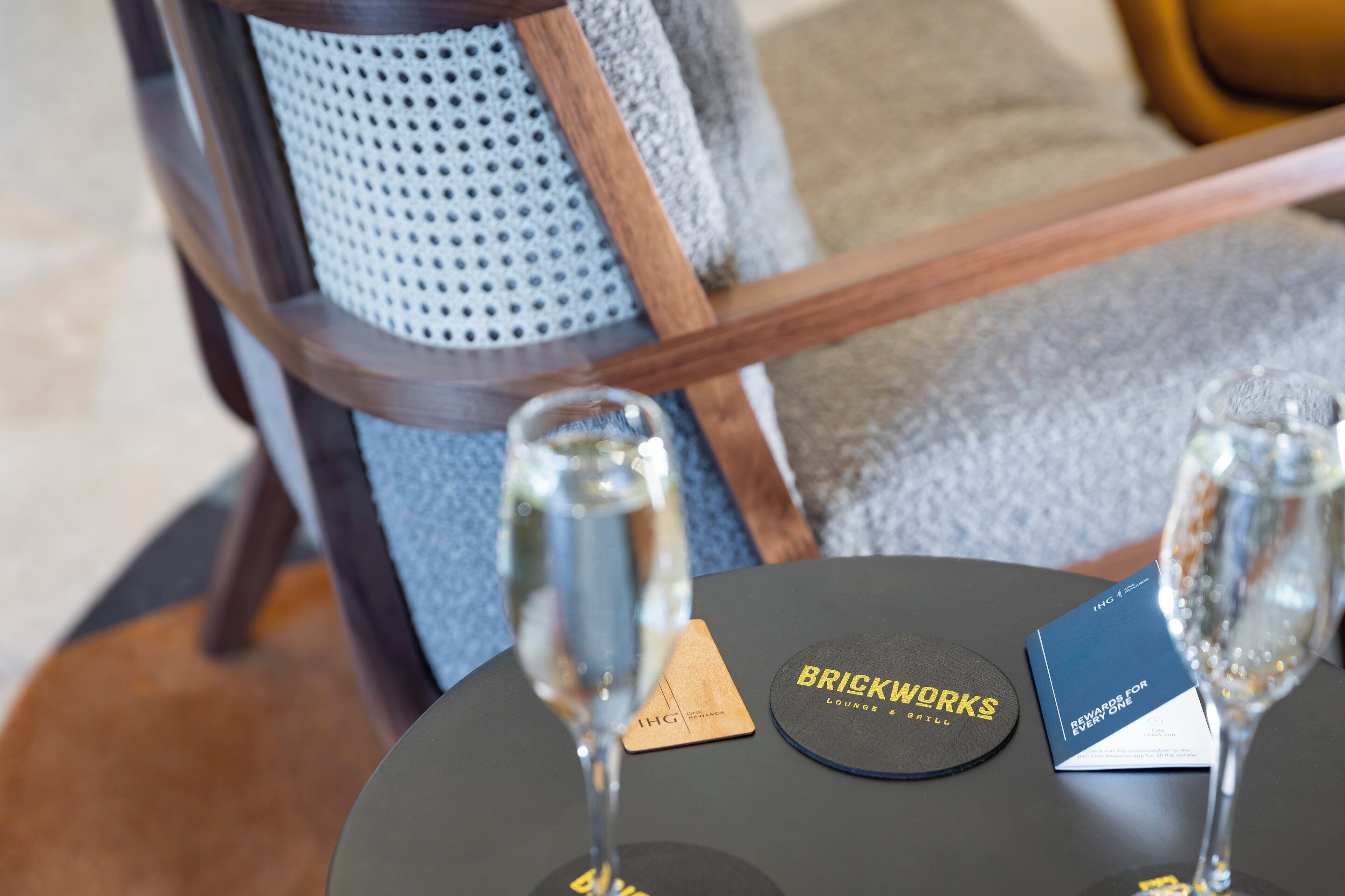 A table with two glasses of water, a coaster with "BRICKWORKS" text, and a menu card.