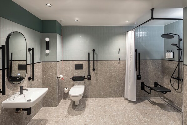 A modern bathroom with a sink, toilet, and shower area.