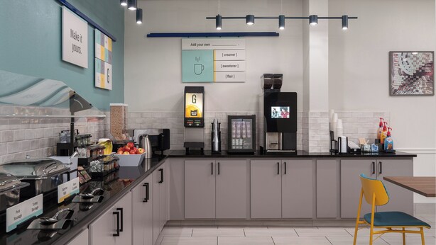 A modern kitchen with a coffee machine, a digital scale, and a variety of food items on the counter. - Garner Hotel Wytheville East by IHG (Wytheville)