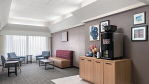 A modern hotel room with a seating area, a coffee machine, and artwork on the walls. - Garner Hotel Wytheville East by IHG (Wytheville)