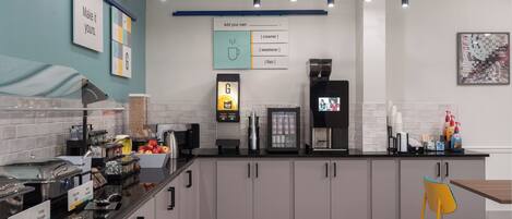 Una cocina moderna con una cafetera, una balanza digital y diversos alimentos sobre la encimera.