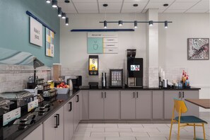 Una cocina moderna con una cafetera, una balanza digital y diversos alimentos sobre la encimera.