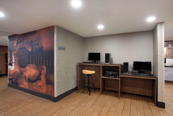 A modern office space with a large abstract mural, two computer monitors, a keyboard, and a stool. - Comfort Inn & Suites Nashville Downtown – Stadium (Nashville)