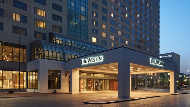 Un hotel Westin con una vasta facciata in vetro, diversi piani e un ingresso ben visibile con insegna.