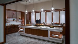 Una cucina moderna con isola centrale, mobili in legno e luci a sospensione.