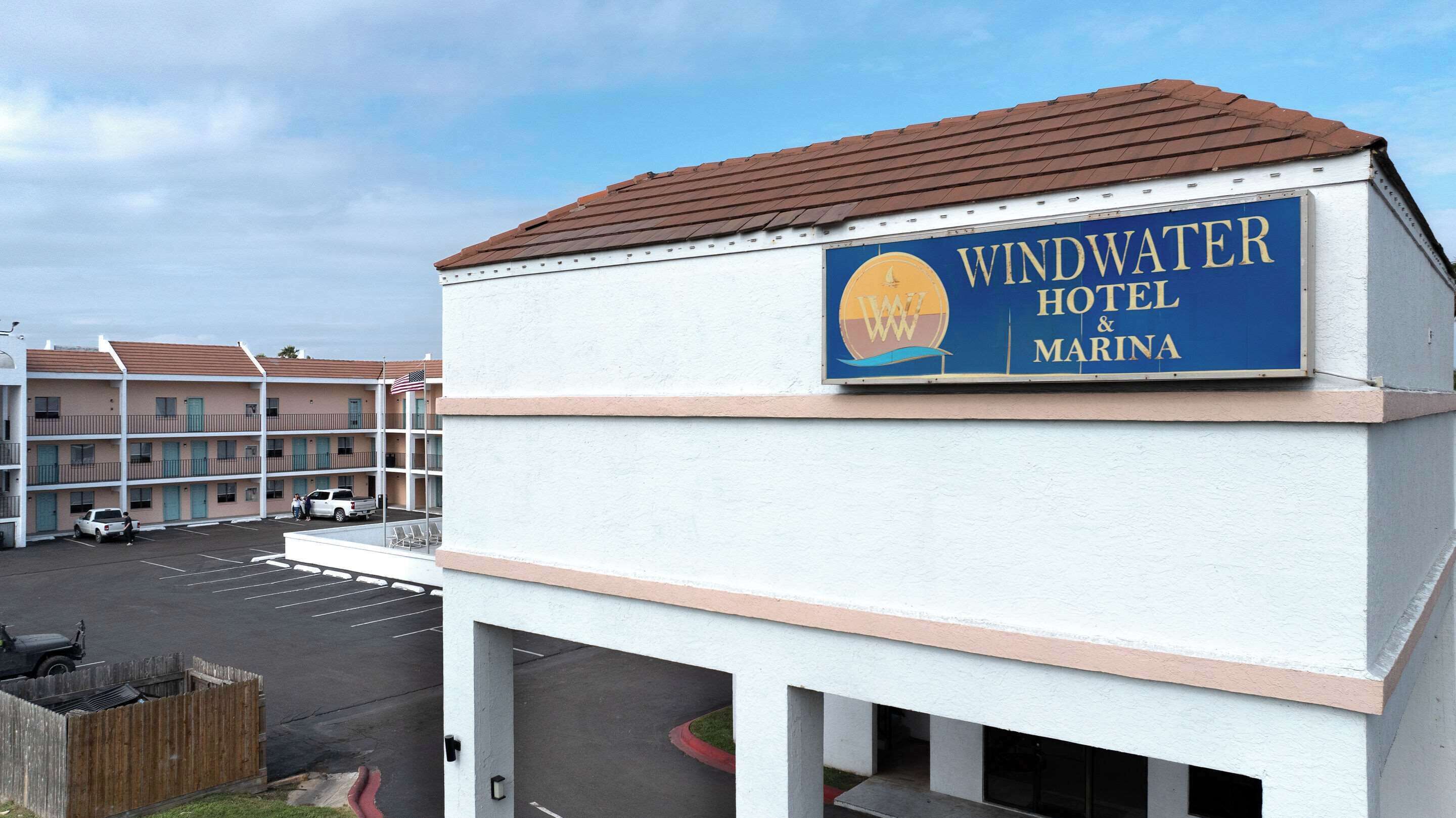 Une enseigne de l’hôtel Windwater et de sa marina est apposée sur un bâtiment devant lequel se trouve un parking.